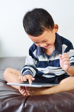 bir çocuk bilgisayar tablet üzerinde bir oyun oynuyor