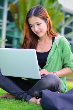 güzel genç Asyalı öğrenci bilgisayar nootbook ile gülümseyen