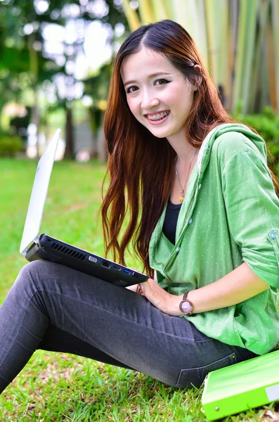 Bella giovane studente asiatico sorridente con computer nootbook — Foto Stock