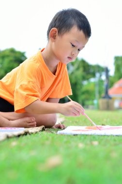 Okula geri dönmek: çizim ve boyama üzerinde yeşil çimen çocuk