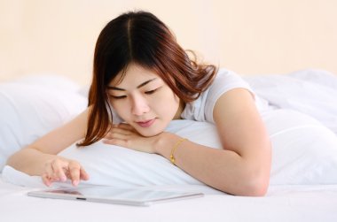 Asyalı genç konuşuyor ve tablet ile sohbet