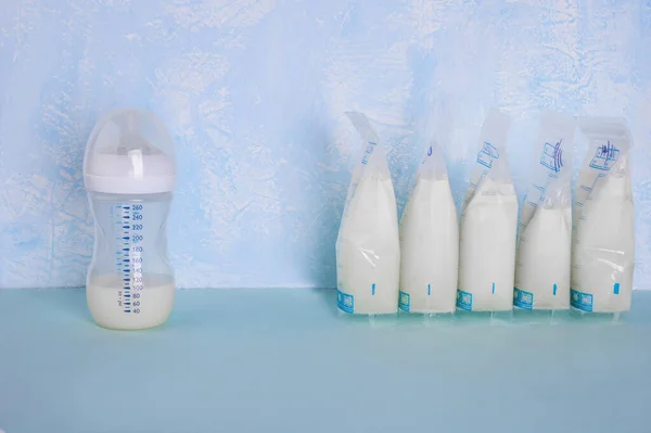 Väskor Med Bröstmjölk Blå Bakgrund Befästande Mjölk Mjölkflaska Arbetande Mamma — Stockfoto