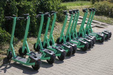 Electric scooters for public share standing outside in european city center public mobile transport, selective focus