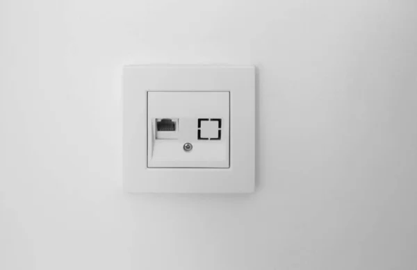 Socket for internet or telephone or cable TV on white wall, close up