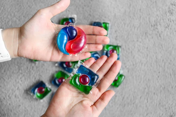 choice of different capsules for washing, capsules with laundry gel in woman hand