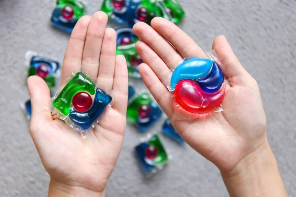 choice of different capsules for washing, capsules with laundry gel in woman hand