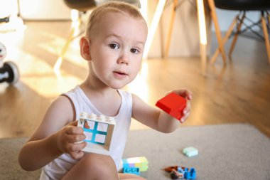 Two years old child collects constructor at home