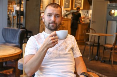 Sabahları kahve ya da çay içen bir adam.