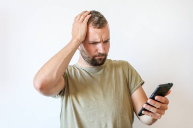 Genç, duygusal sakallı adamlar akıllı telefona dikkatle bakıyorlar.