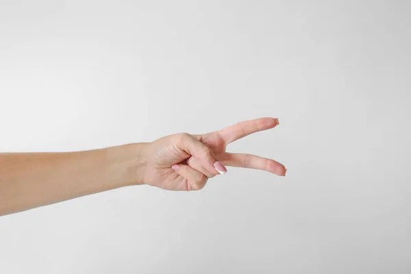 Женщина Держит Два Пальца Белом Фоне — стоковое фото