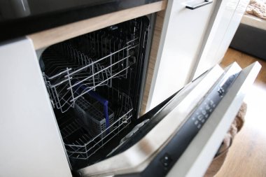 Dishwasher. Loading dishes. Dishwashing capsules. Open dishwasher with clean dishes in the white kitchen. Opening and closing the dishwasher.