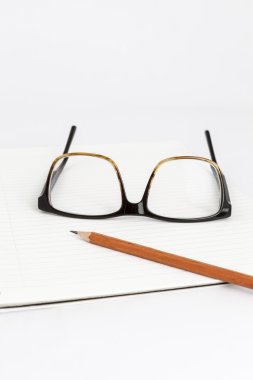 bir defter üstünde kırmızı gözlük