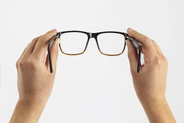 Woman hand holding black glasses — Stock Photo, Image