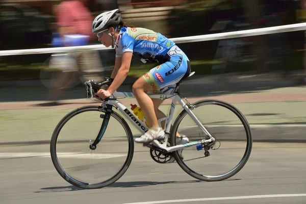PLOIESTI-BUCHAREST - JULY, 05: Panning of a beautiful girl riding bicycle in a sunny day, fighting for Road Grand Prix event, a high-speed circuit race, July 05, 2014 in Ploiesti-Bucharest, Romania — Stok Foto