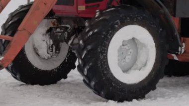 Sarı kovalı bir traktör kışın karları sokaktan kaldırır. Yol temizleme, endüstri. Yavaş çekim