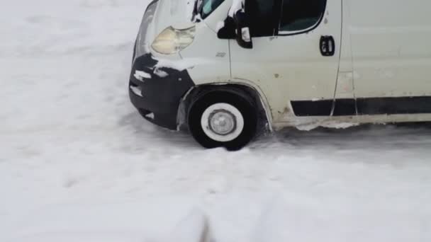 De auto glijdt uit in de sneeuw waaronder in de winter ijs op de weg ligt. Ernstige sneeuwstorm, sneeuwdrift — Stockvideo