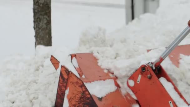 Traktor se žlutým kbelíkem odstraňuje sníh z ulice v zimě. Pomoc při čištění silnic, průmysl — Stock video