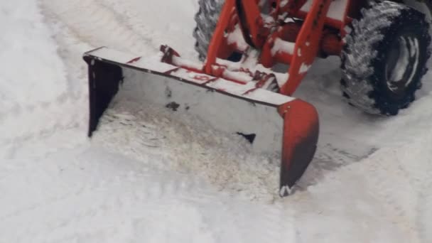 Погрузчик с желтым ведром очищает дорогу и убирает снег зимой. Оборудование для удаления снега — стоковое видео