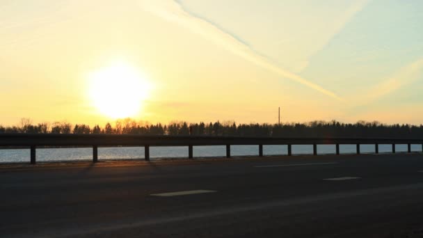 Samochody i furgonetki jeżdżą autostradą w mroźny zimowy wieczór z zachodem słońca w tle. Koncepcja ruchu drogowego i transportu pasażerskiego. Kopiuj miejsce na tekst, podróż — Wideo stockowe