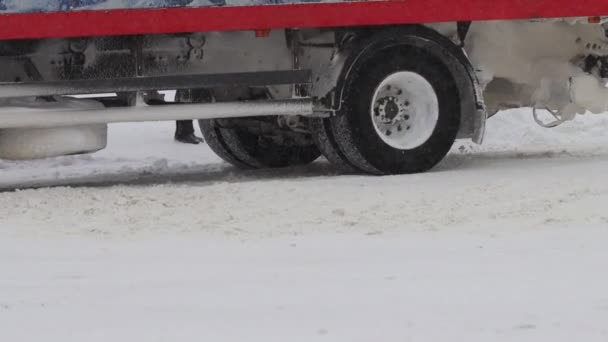 トラックの車は冬に雪道を運転している。遅い動きでホイールタイヤの閉じます。交通のための悪天候、吹雪。旅の危険 — ストック動画