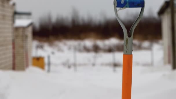 Ένα φτυάρι χιονιού θάβεται στο χιόνι στην αυλή το χειμώνα. Αφαίρεση χιονιού. Αντιγραφή χώρου για κείμενο — Αρχείο Βίντεο