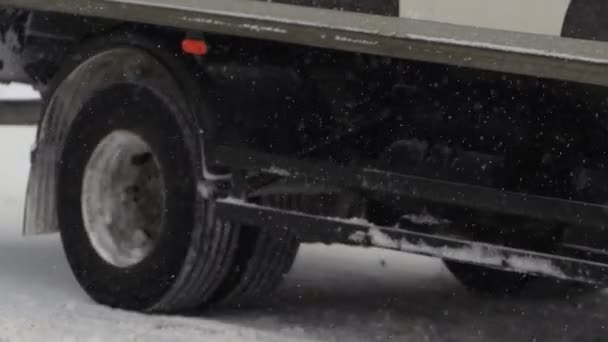 Lastwagenfahrer fährt im Winter auf schneeglatter Straße. Nahaufnahme eines Radreifens in Zeitlupe. Schlechtes Wetter für den Verkehr, Schneesturm. Gefahr für die Reise — Stockvideo