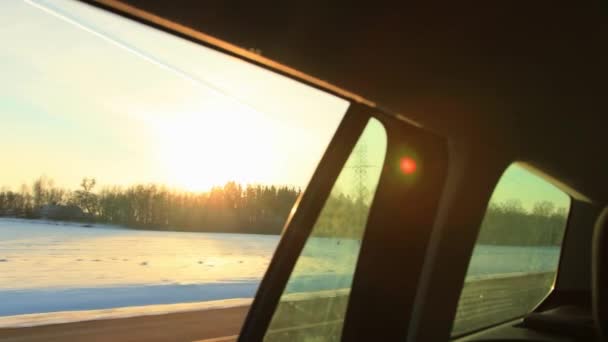 Utsikt från bilfönstret över vinternaturen i rörelse. Vacker skog och solnedgång, bakgrund — Stockvideo