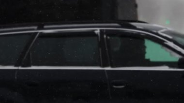 Kış. Şehirdeki karlı bir yolda arabalar sürüyor. Ağır çekimde kar yağışı. Trafik ve kar fırtınası için kötü hava koşulları. Trafik kazası tehlikesi. Kesişen yol