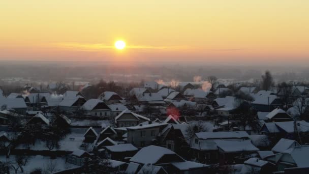 Pomarańczowy wschód słońca w mroźny zimowy poranek na tle wsi. Piękne niebo i śnieg — Wideo stockowe