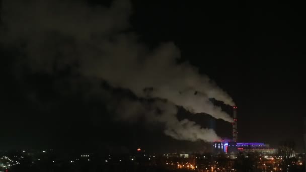 Asap dari cerobong asap pembangkit listrik pada malam musim dingin yang dingin. Malam meriah lampu kota, waktu-lapse — Stok Video