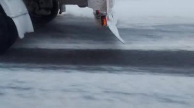 Karlı kış yolunda yarı römorklu bir kamyonu sollamak. Kamyon şasisi ve tekerlek dönüş yolu karla kaplı, tekerlek tutuşu