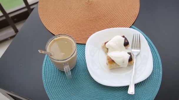 Pagi sarapan di balkon, pancake dengan krim asam dan isian dengan daging, kopi dengan susu dalam cangkir. — Stok Video