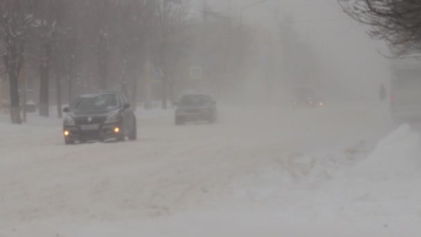 Winter. Heftiger Schneesturm. Autos fahren auf einer verschneiten Straße in der Stadt. Schneefall in Zeitlupe. Schlechte Wetterbedingungen für den Verkehr. Gefahr von Verkehrsunfällen. Weggabelung — Stockvideo