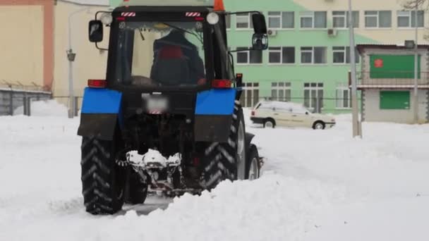 Traktor čistí sněhové hory v zimním městě na sněhu, průmysl — Stock video