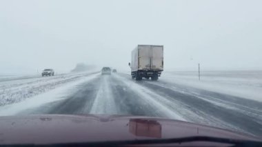 BOBRUISK-MINSK, BELARUS - 9 Şubat 2021: karlı bir pistle kaygan bir kış yolu üzerinde sürüş. Araba trafiği, görünmeyen sürüş