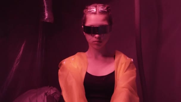Concepto futuro cyberpunk. El cyborg biónico semirobot femenino apunta a la cámara y dispara pistola de revólver dentro de la habitación con iluminación roja. Escena de ciencia ficción, fantasía. Mundo del mañana. En el set — Vídeo de stock
