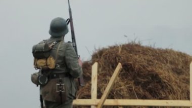 Dünya Savaşı sırasında Alman ordusunun Wehrmacht üniformalı sakallı askeri 22 Haziran 1941 'de Sovyetler Birliği' nde işgalin yeniden inşası sırasında elinde tüfekle elini sallıyordu.