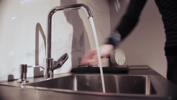 Adam mutfaktaki musluğu açar ve kapatır. Su kaynağı faturaları kavramı. Metin için alanı kopyala — Stok video