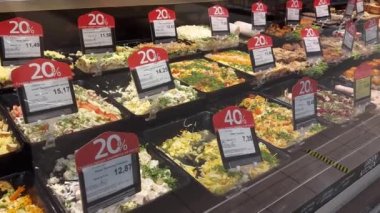 Yiyecek satan bir mağazanın vitrininde bir sürü kırmızı etiket var. Salata indirimi ve satış konsepti, geçmiş