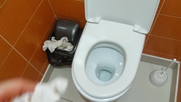 Un homme jette du papier toilette sur le sol des toilettes. Toilettes non nettoyées, déchets dans les toilettes publiques, problème — Video