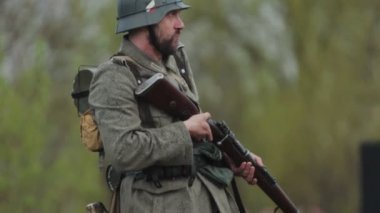 İkinci Dünya Savaşı sırasında Alman ordusunun Wehrmacht üniformalı sakallı askeri Sovyetler Birliği 'nde 1941 SSCB işgalinin yeniden inşası sırasında tüfeğini tutuyor, elini sallıyor ve savaşa hazırlanıyor.