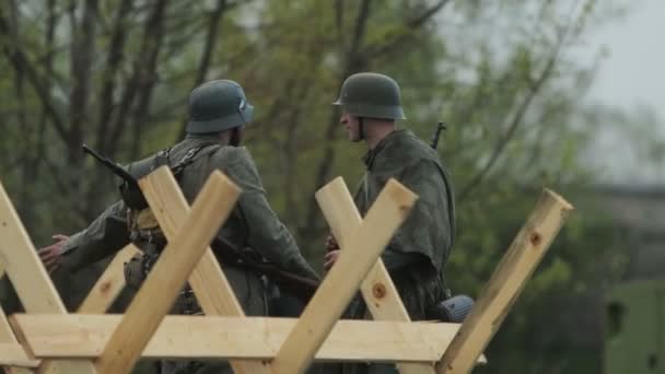 ドイツ軍の制服を着た2人のドイツ兵が、ソビエト連邦への侵攻の再建中の1941年6月22日、ソビエト連邦に対する東側戦線の第二次世界大戦中に話し合っている。. — ストック動画