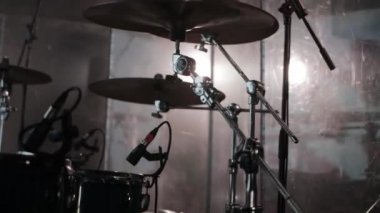 Bir gece kulübündeki davul seti dumanın ve spot ışıklarının arasında, müzik aleti