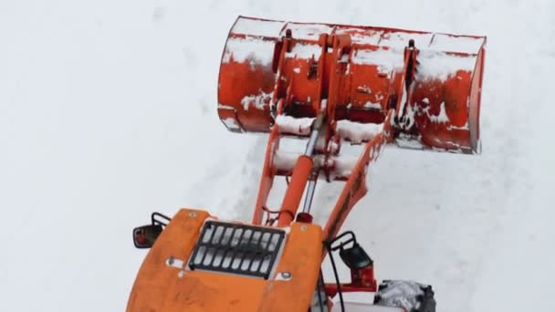 Sárga rakodó egy vödör eltávolítja a havat télen az udvaron. Lassú mozgás. — Stock videók