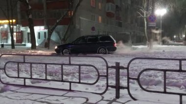 Şoför arabayı karda mahsur bırakmaya çalışıyor. Araba stop ediyor, kayıyor ve kayıyor. Yoldaki tekerlekler kayar ve döner. Kış gecesi. Trafik kazası tehlikesi var. Kötü hava koşulları