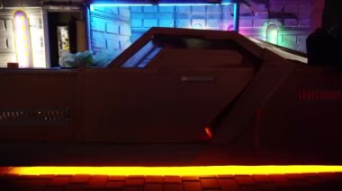Siber punk konsepti. Punk tarzı saç kesimi olan garip bir tip gece vakti fütüristik arabadan iniyor. Neon ışıkları. Bilim kurgu sahnesi, fantezi. Yarının Dünyası.