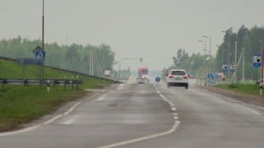Yağmurlu havalarda otoyolda farları yanan araba ve kamyonlardan gelen trafik. Zaman aşımı, arkaplan