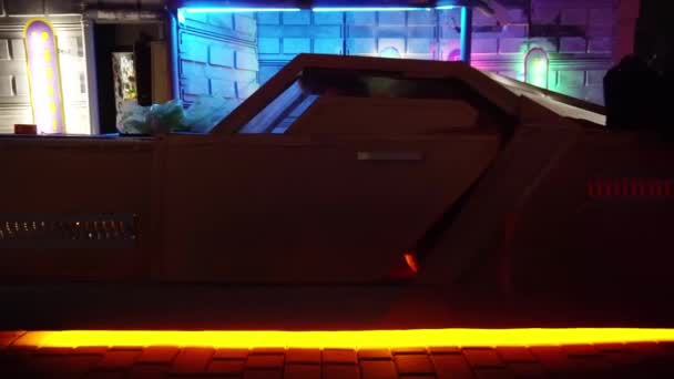 Cyberpunk-Konzept. Seltsame Figur mit Punk-Frisur steigt nachts aus futuristischem Auto auf der Straße aus. Neonbeleuchtung. Science-Fiction-Szene, Fantasy. Die Welt von morgen. — Stockvideo