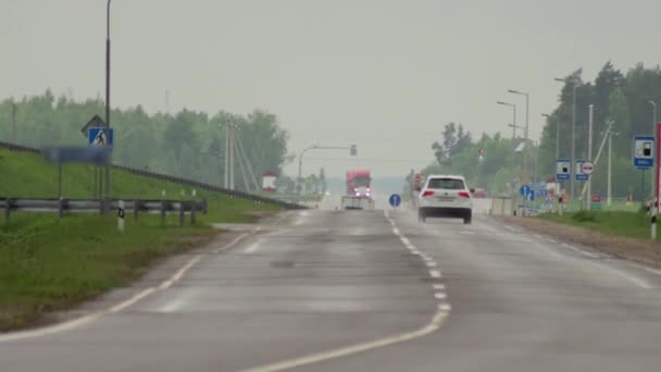 Verkeer van auto 's en vrachtwagens met koplampen op de snelweg bij regenachtig weer. Tijdsverloop, achtergrond — Stockvideo