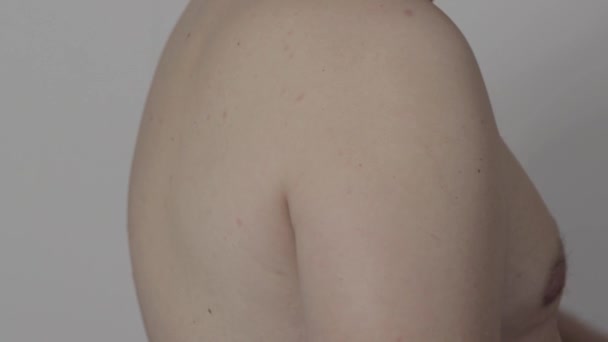 Un hombre se pone un parche antiinflamatorio en la articulación del hombro, de cerca — Vídeos de Stock